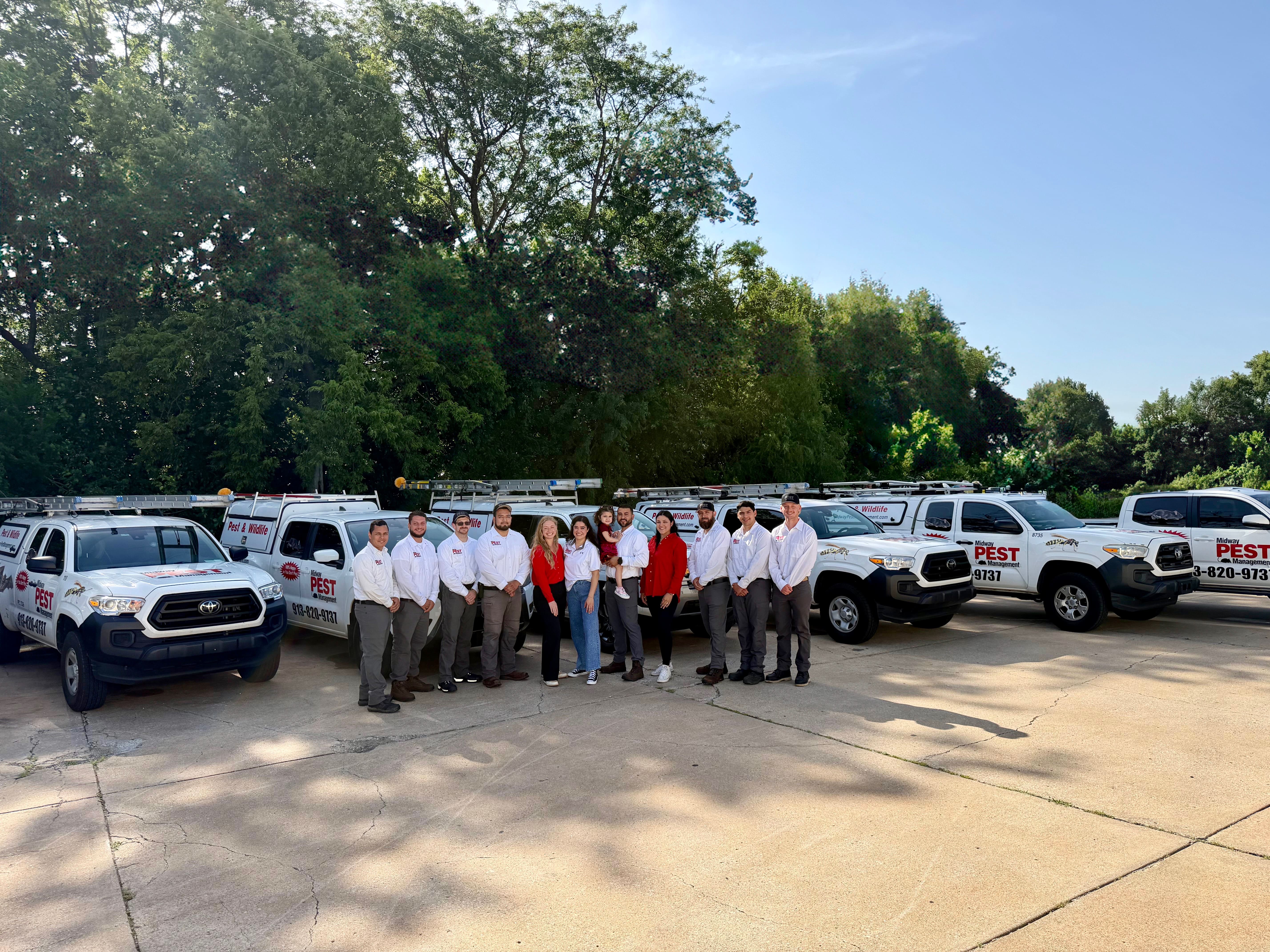 The Midway Pest Management team standing with the company truck fleet in Olathe, Kansas